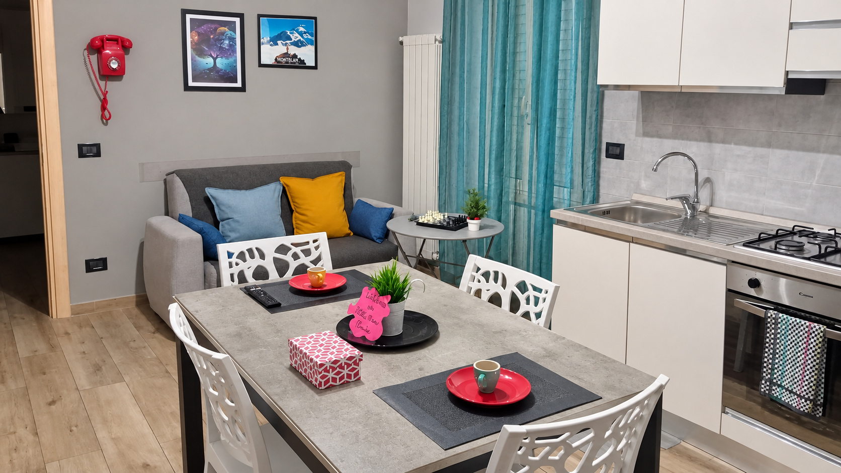 The living room with the kitchen and the table for four