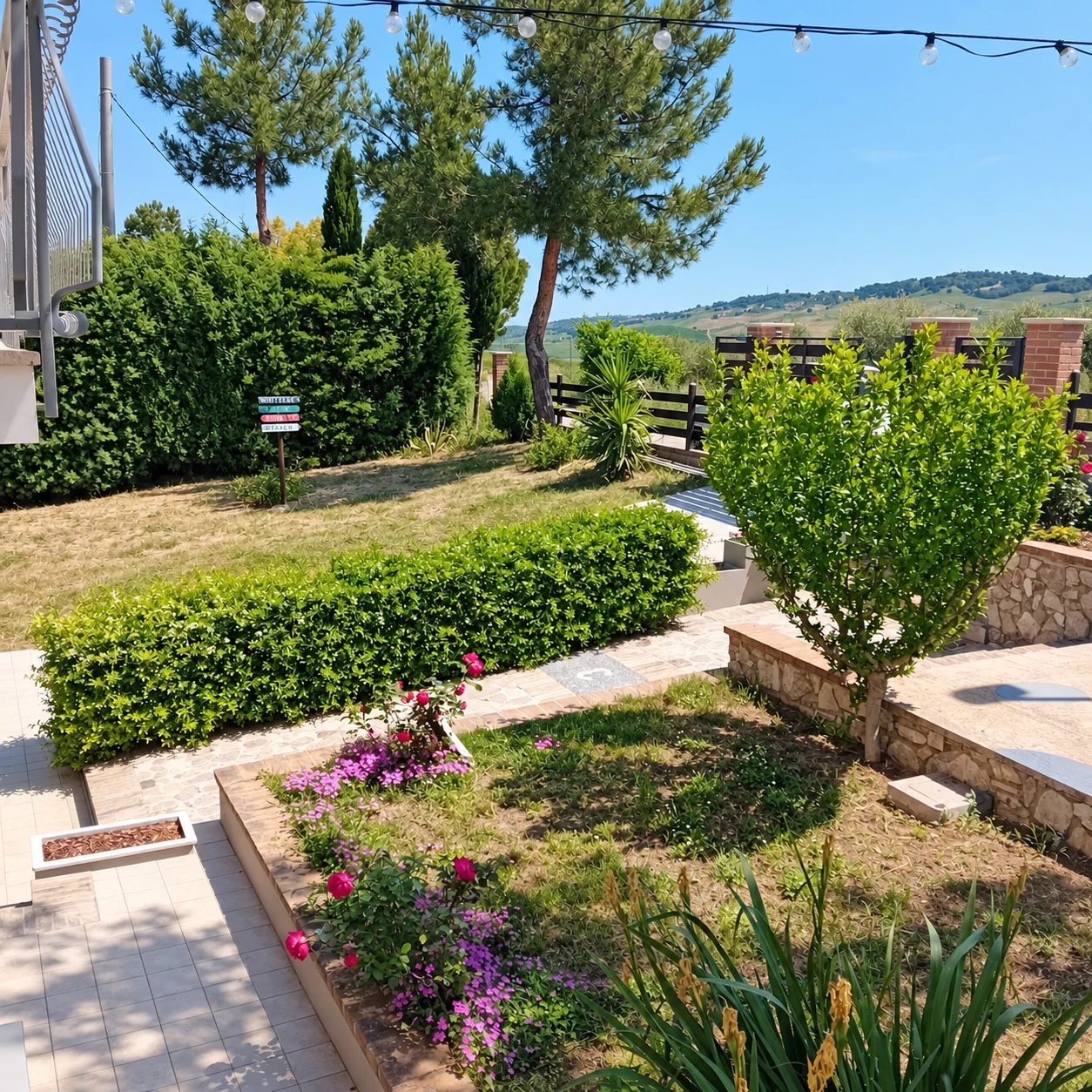 Giardino con siepi, fiori e colline sullo sfondo