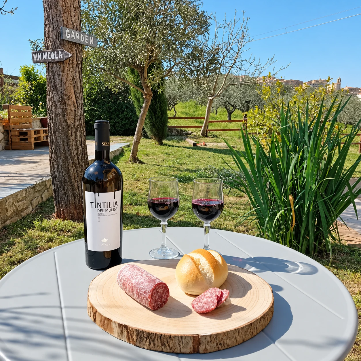 Tagliere, pane e vino sul tavolino in giardino